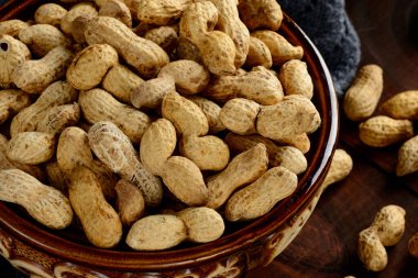 Arka planda bir kasede yer fıstığı. Kabuklu fıstıklar. Sağlıklı yemek..