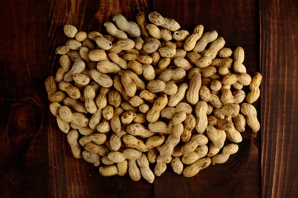 Peanuts on a dark background. Peanuts in a shell. Healthy food.