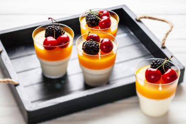 Tahta tepside böğürtlen ve kirazlı 4 bardak mango pannacota.