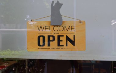 Kapalı ahşap tabela, hoş geldiniz, açığız, lütfen dükkanın önünde iple sallanarak gelin. 