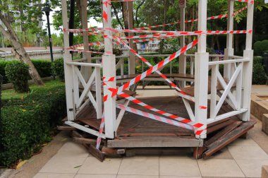 Ahşap pavyonu çevreleyen barikat bandına odaklanın. İnsanlar toplanamaz. Koronavirüs salgınından dolayı sosyal mesafeyi korumak zorundalar.  