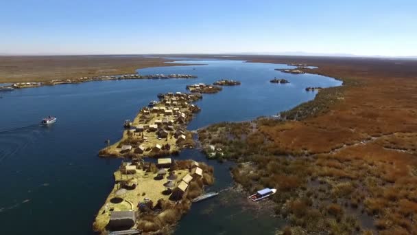 ペルーの空中ドローン上面に浮かぶウロス島 フローティングアイランドはティティカカ湖の浅瀬にあるトトラの切り立った層からウロス人によって建設された小さな人工島です — ストック動画