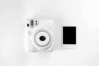 Modern polaroid fotoğraf makinesi, beyaz tahta arka plan. Üst manzara, yumuşak minimum düz konum kompozisyonu. moda blogcusu, güzellik teknolojisi