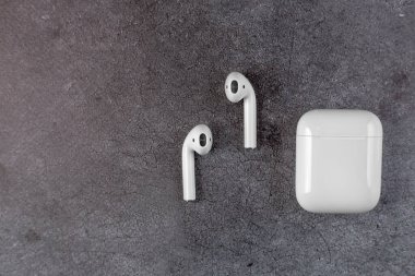 Adam hava kapsüllerini elinde tutuyor. Hava kapsülleri. Kablosuz şarj davasıyla. Kazı metal arka planda yeni hava araçları. Hava podları. Boşluğu kopyala