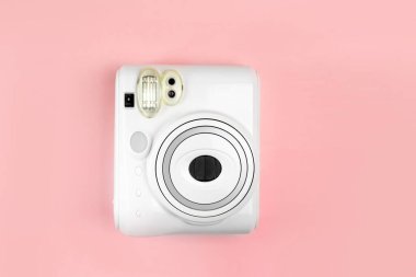 Modern polaroid kamera, pembe arka plan. Üst manzara, yumuşak minimum düz konum kompozisyonu. moda blogcusu, güzellik teknolojisi