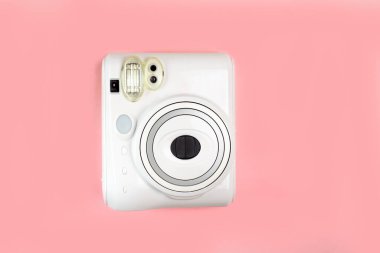 Modern polaroid kamera, pembe arka plan. Üst manzara, yumuşak minimum düz konum kompozisyonu. moda blogcusu, güzellik teknolojisi