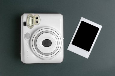 Modern polaroid kamera, yeşil arka plan. Üst manzara, yumuşak minimum düz konum kompozisyonu. moda blogcusu, güzellik teknolojisi