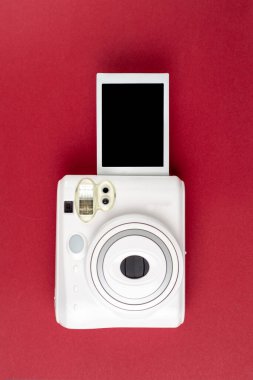 Modern polaroid kamera, kırmızı arka plan. Üst manzara, yumuşak minimum düz konum kompozisyonu. moda blogcusu, güzellik teknolojisi