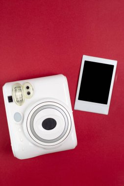 Modern polaroid kamera, kırmızı arka plan. Üst manzara, yumuşak minimum düz konum kompozisyonu. moda blogcusu, güzellik teknolojisi