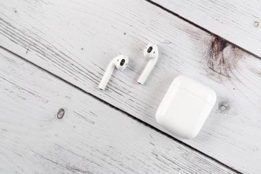 Hava kapsülleri. Kablosuz şarj davasıyla. Yeni hava araçları 2019 beyaz masada. Hava podları. Adamın elinde kulaklık var.