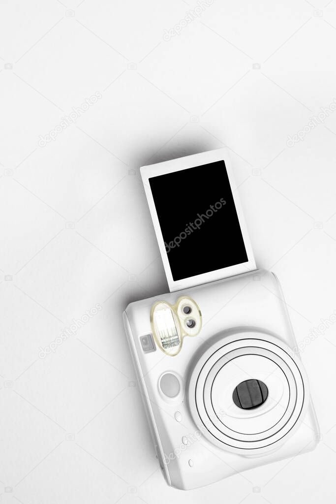 Modern polaroid camera, white background. Top view, tender minimal flat lay style composition. fashion blogger, beauty technology