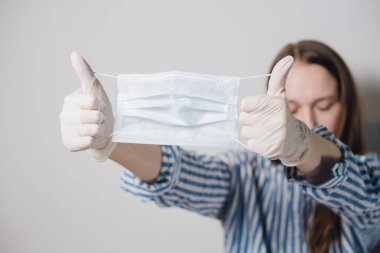 Kızın ellerinde tıbbi bir maske var. Corona virüsünün önlenmesi. Biyolojik koruyucu salgın virüsü salgını bilim adamı. COVID-19