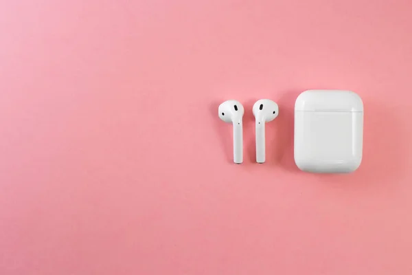 white headphones on a pink background. female headphones