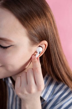 Hava kapsülleri uzmanı. Kablosuz şarj davasıyla. Pembe arka planda New Airpods profesyoneli. Hava kapsülü. Kadın kulaklıkları. Boşluğu Kopyala