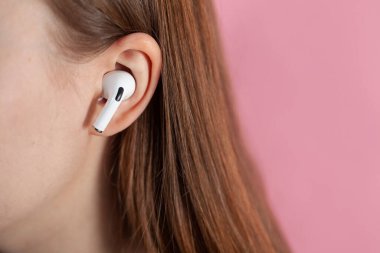Hava kapsülleri uzmanı. Kablosuz şarj davasıyla. Pembe arka planda New Airpods profesyoneli. Hava kapsülü. Kadın kulaklıkları. Boşluğu Kopyala