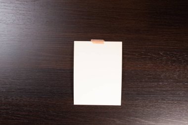 Yumuşak gölgeli boş polaroid fotoğraf çerçevesi ve beyaz kağıt arkaplanda izole edilmiş selobant grafik tasarımcıları sunumları için şablon, portföy vs. Ahşap arka planda beyaz yapraklar.