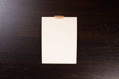 Yumuşak gölgeli boş polaroid fotoğraf çerçevesi ve beyaz kağıt arkaplanda izole edilmiş selobant grafik tasarımcıları sunumları için şablon, portföy vs. Ahşap arka planda beyaz yapraklar.