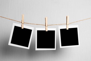 Polaroid çerçeve. Beyaz arkaplanda izole edilmiş ipte asılı duran eski fotoğraf çerçeveleri. gerçek fotoğraf.