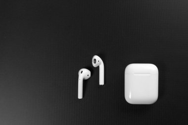 Air Pods. with Wireless Charging Case. New Airpods 2019 on black background. Airpods. Copy space. clipart