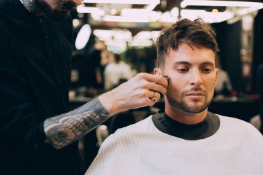 Berber dükkanında portre adam profesyonel elektrikli makasla kırpılıyor. Erkek güzellik tedavi konsepti. Berber salonunda yeni saç kesimi yaptıran adam..