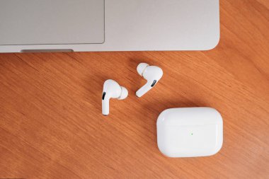Hava Modülleri Pro. Macbook. Kablosuz şarj davasıyla. Ahşap arka planda yeni hava araçları profesyoneli. Hava podları. Boşluğu kopyala,