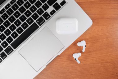 Hava Modülleri Pro. Macbook. Kablosuz şarj davasıyla. Ahşap arka planda yeni hava araçları profesyoneli. Hava podları. Boşluğu kopyala.
