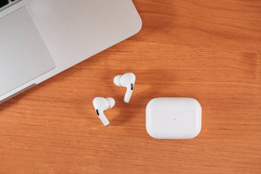 Hava Modülleri Pro. Macbook. Kablosuz şarj davasıyla. Ahşap arka planda yeni hava araçları profesyoneli. Hava podları. Boşluğu kopyala,