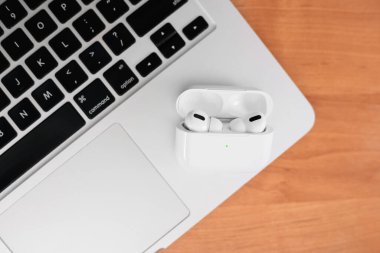 Hava Modülleri Pro. Macbook. Kablosuz şarj davasıyla. Ahşap arka planda yeni hava araçları profesyoneli. Hava podları. Boşluğu kopyala,