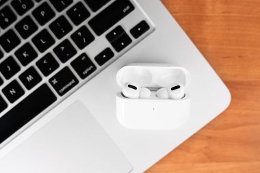 Hava Modülleri Pro. Macbook. Kablosuz şarj davasıyla. Ahşap arka planda yeni hava araçları profesyoneli. Hava podları. Boşluğu kopyala,
