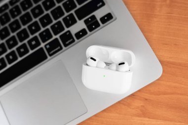Hava Modülleri Pro. Macbook. Kablosuz şarj davasıyla. Ahşap arka planda yeni hava araçları profesyoneli. Hava podları. Boşluğu kopyala,