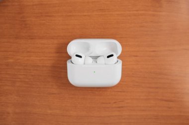 Air Pods Pro. with Wireless Charging Case. New Airpods pro on wooden background. Airpods. Copy space. clipart