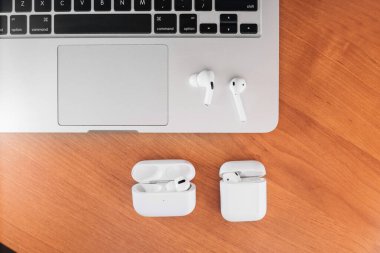 Hava Modülleri Pro. Macbook. Kablosuz şarj davasıyla. Ahşap arka planda yeni hava araçları profesyoneli. Hava podları. Boşluğu kopyala.
