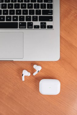 Hava Modülleri Pro. Macbook. Kablosuz şarj davasıyla. Ahşap arka planda yeni hava araçları profesyoneli. Hava podları. Boşluğu kopyala,