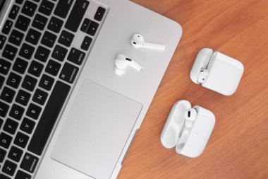 Hava Modülleri Pro. Macbook. Kablosuz şarj davasıyla. Ahşap arka planda yeni hava araçları profesyoneli. Hava podları. Boşluğu kopyala,