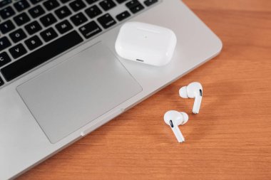 Hava Modülleri Pro. Macbook. Kablosuz şarj davasıyla. Ahşap arka planda yeni hava araçları profesyoneli. Hava podları. Boşluğu kopyala,