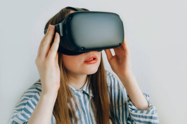 Gözlükler. Sanal gerçeklikte beyaz arka plan görüntüsü olan VR gözlüklü kız, artırılmış gerçeklik gözlükleri. VR gözlüklü kız.