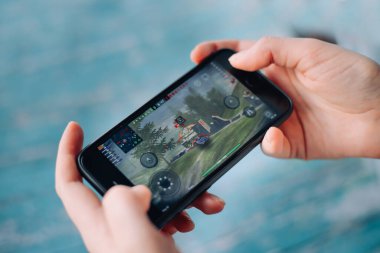 Aziz PETERSBURG, Rusya - 27 Mayıs 2020: ellerinde siyah iPhone. Ekranda World of Tanks oynanıyor. World of Tanks Blitz. oyun wot blitz