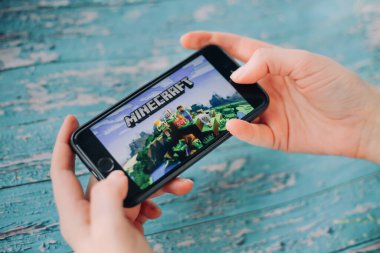 SAINT PETERSBURG, RUSSIA - 27 Mayıs 2020: Minecraft Pocket Edition oyunu ile akıllı telefonu tutan eller ekranda, Illustrative Editorial.