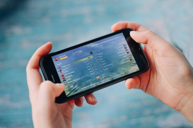 Aziz PETERSBURG, Rusya - 27 Mayıs 2020: ellerinde siyah iPhone. Ekranda World of Tanks oynanıyor. World of Tanks Blitz. oyun wot blitz