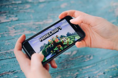 SAINT PETERSBURG, RUSSIA - 27 Mayıs 2020: Minecraft Pocket Edition oyunu ile akıllı telefonu tutan eller ekranda, Illustrative Editorial.