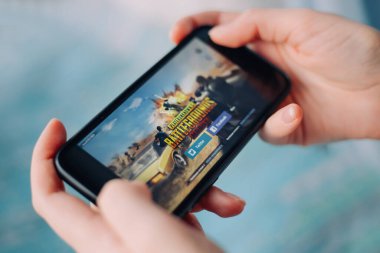 SAINT PETERSBURG, RUSSIA - 27 MAYIS 2020: PUBG FPS oyunu ile akıllı telefon tutan eller