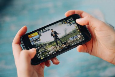 SAINT PETERSBURG, RUSSIA - 27 MAYIS 2020: PUBG FPS oyunu ile akıllı telefon tutan eller