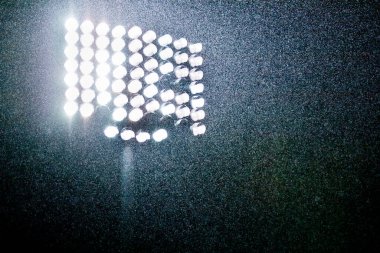 Parlak ışıkların altında sağanak yağmur