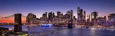 Doğu Nehri üzerindeki Brooklyn Köprüsü ve Manhattan şehir merkezindeki panoramik gökyüzü gece New York 'ta.
