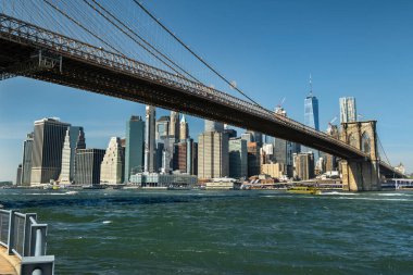 Brooklyn Köprüsü 'nün altındaki East River kıyı şeridi New York' taki DUMBO bölgesinden görüldüğü gibi.