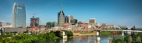 Nashville Tennessee panoramik şehri ve Tennessee ABD 'deki Cumberland Nehri üzerindeki John Seigenthaler yaya köprüsü