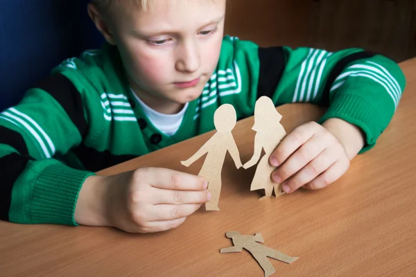 Verwirrtes Kind mit Papierfamilie — Stockfoto