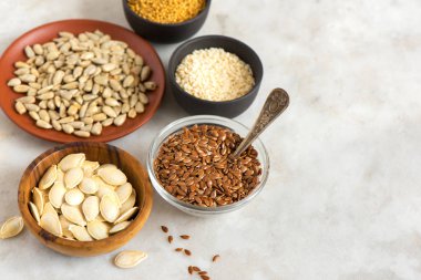 Yağlı tohumlar (keten, susam, kabak, ayçiçeği, hardal) kopya alanı - taş zemin üzerine çeşitli sağlıklı vejetaryen vegan beslenme için organik maddeler