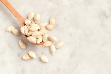 Kabak çekirdeği üzerinde kopya alanı - sağlıklı gıda içerikler ile beyaz taş bsckground