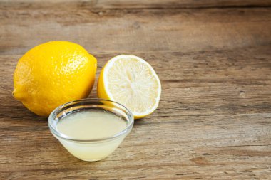 Küçük kase ve limon rustik ahşap arka plan kopya alanı - pişirme ve pişirme için sağlıklı madde ile üzerinde taze limon suyu
